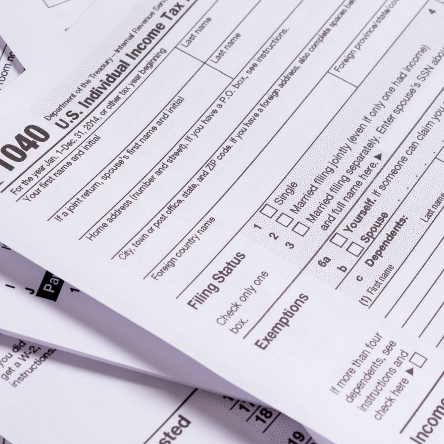 A variety of United States tax forms with a pencil